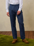Cropped front view of ink blue pleated linen trousers with tan suede loafers