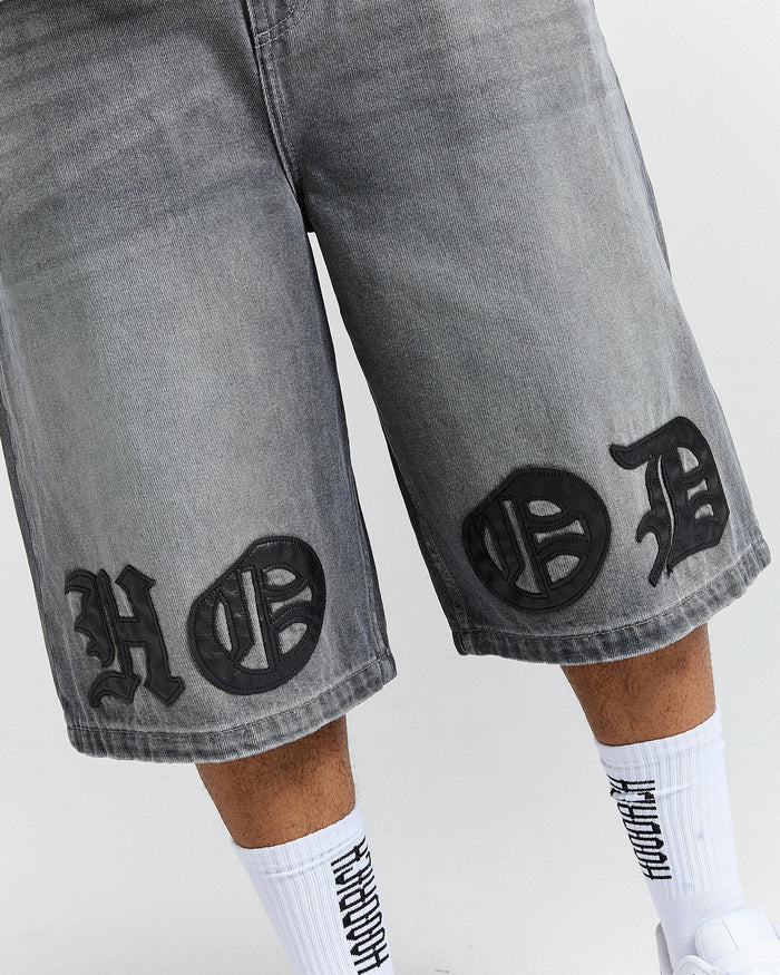 Gray shorts with black patterns and white socks worn by a person on a white background