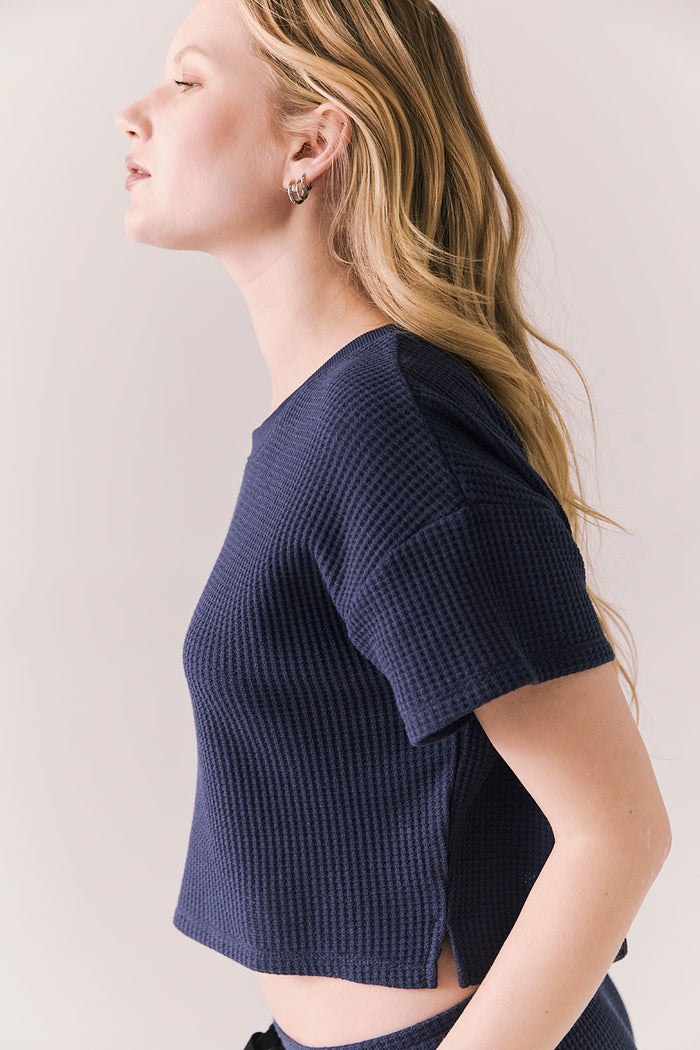 Side view of model in Irvine Tee in midnight blue with soft thermal texture on plain background