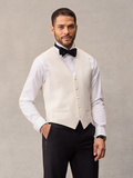 Man in ivory tuxedo vest, black bow tie, and white shirt, hand in pocket