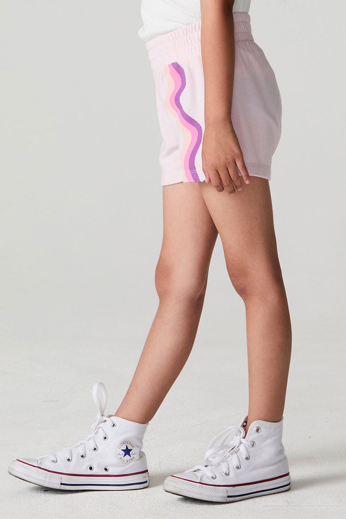 Side angle view of a girl wearing the Chaser Jade Begonia Shorts on a neutral background