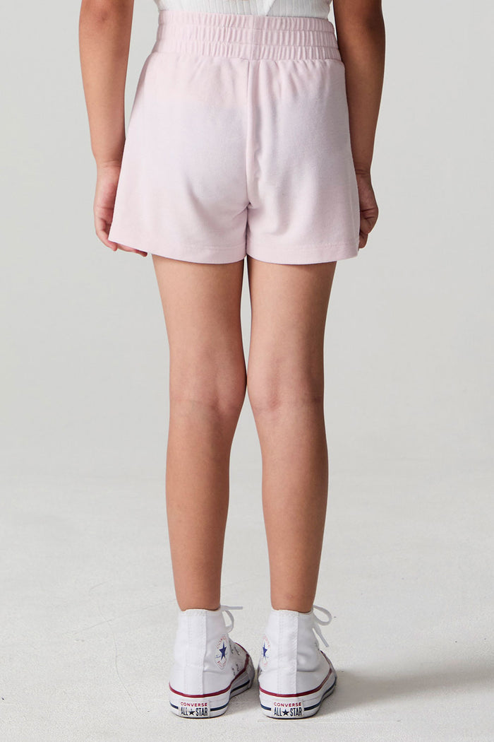 Back view of a girl wearing the Chaser Jade Begonia Shorts on a neutral background