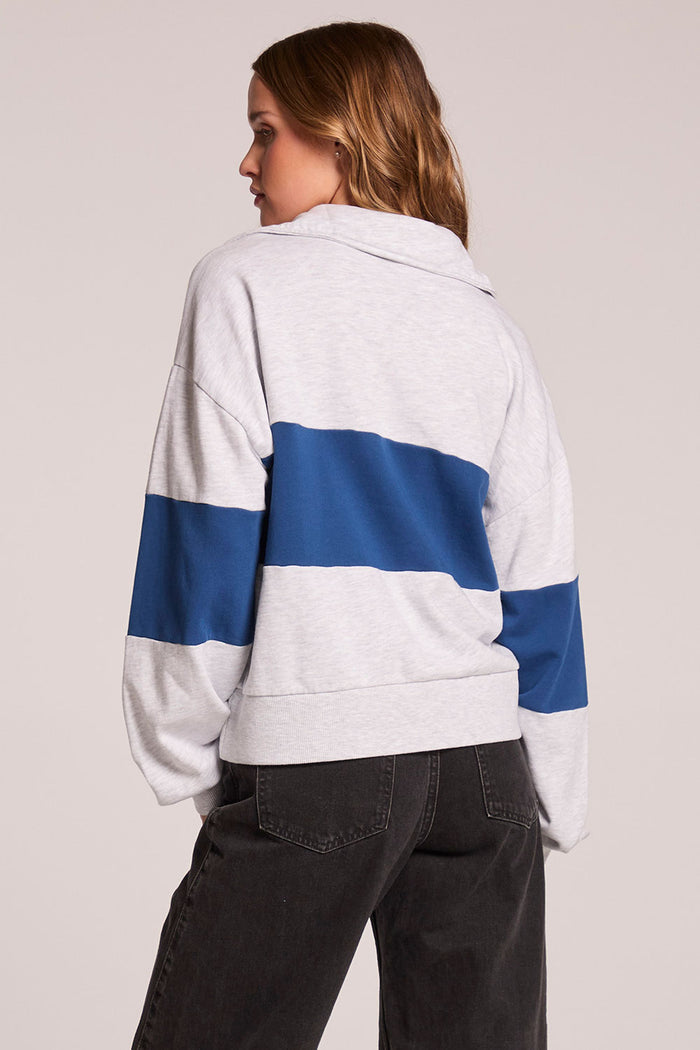 Back view of a woman wearing the Chaser  Jaime Admiral and Grey Half Zip on a neutral background