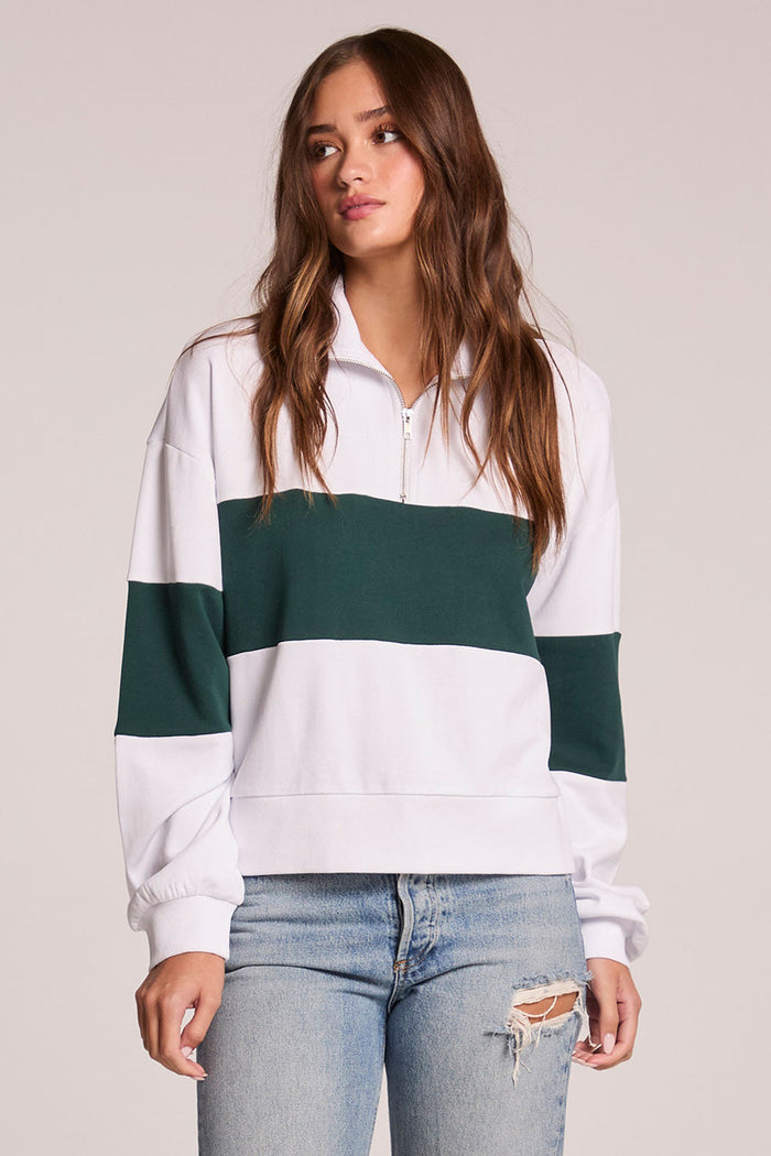 A front view of a woman wearing the Chaser Jaime Pine and White Half Zip on a neutral background with both hands at her sides