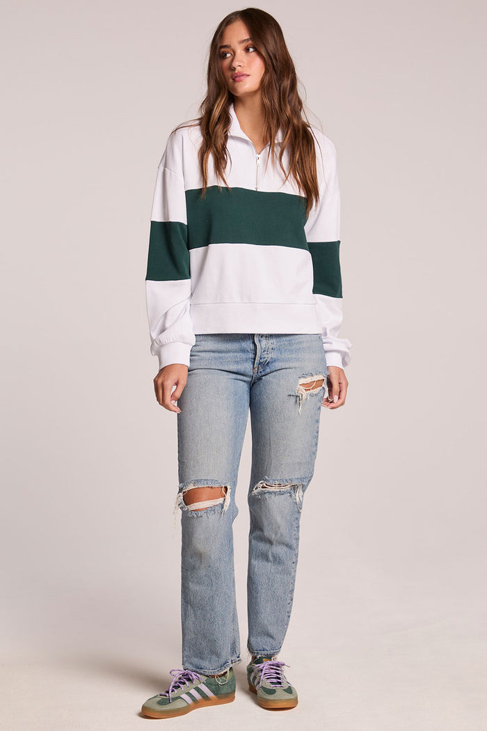 A full body front view of a woman wearing the Chaser Jaime Pine and White Half Zip on a neutral background