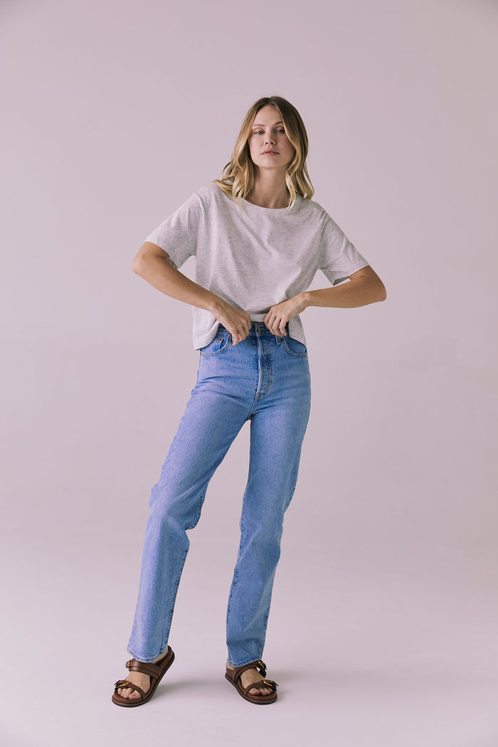 Full body standing view of Chaser Brand Jameson Light Heather Grey Tee styled with light wash jeans and brown slides