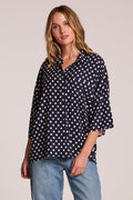 Front view of a woman wearing the Chaser Jemma Navy Spot Button Down and jeans on a neutral background