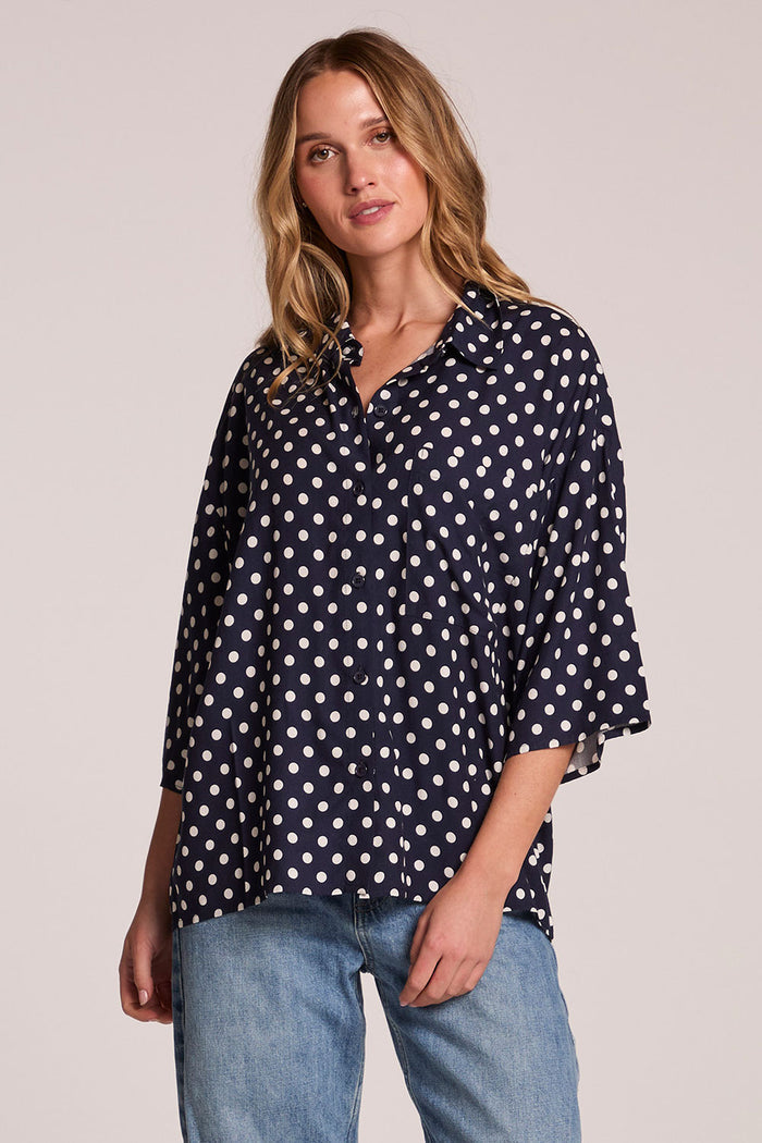Front view of a woman wearing the Chaser Jemma Navy Spot Button Down and jeans on a neutral background