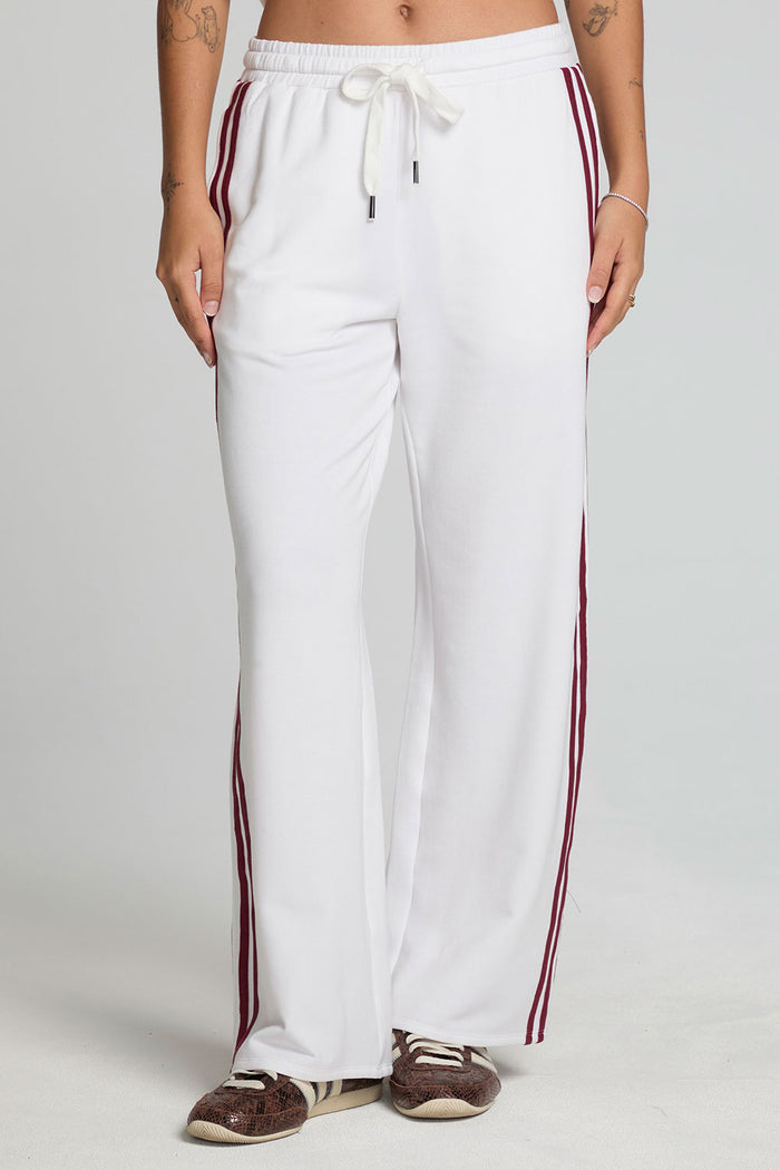 Front view of a woman wearing the Chaser Jessee Cloud White Trackpants on a neutral background with arms down at sides
