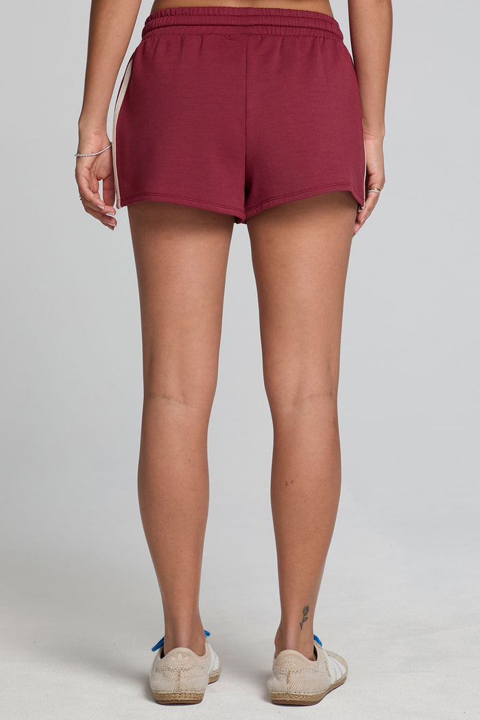 Back view of a woman wearing the Chaser  Jezz Burnt Red Shorts on a neutral background