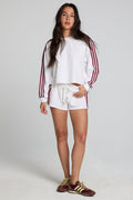 Full body front view of a woman wearing the Chaser Jezz Cloud White Shorts on a neutral background with matching white top