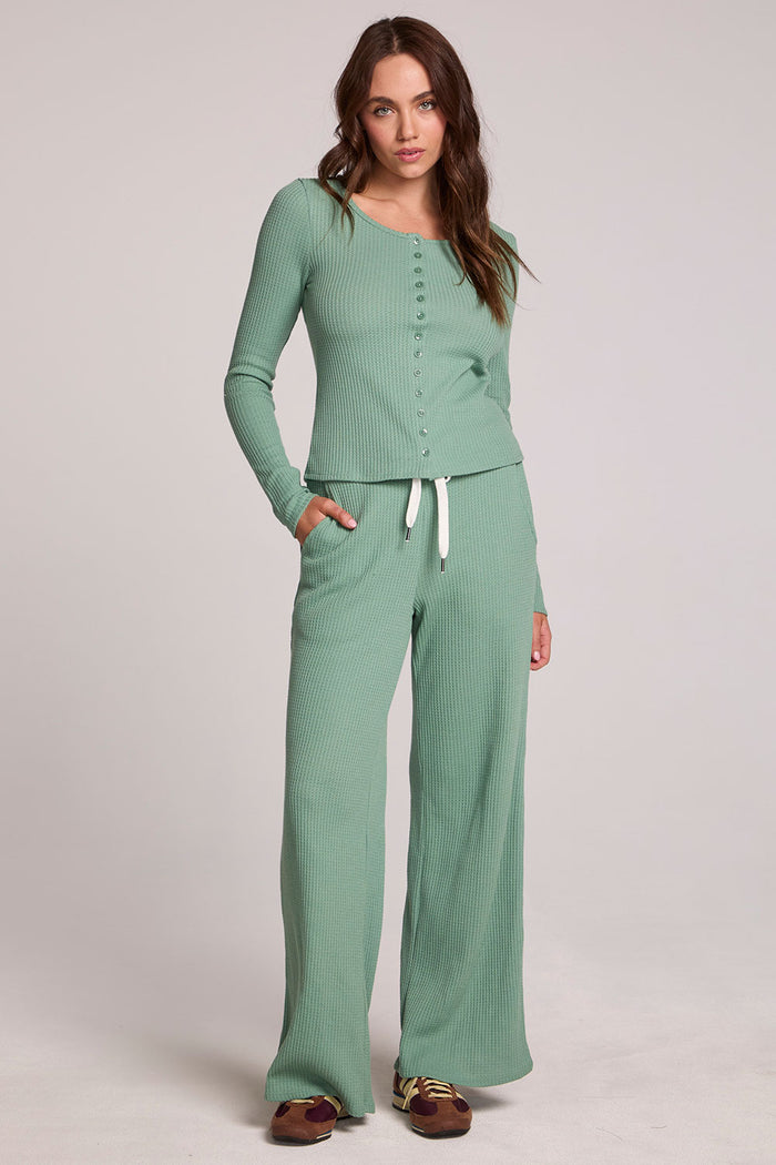 Full body front view of a woman wearing the Chaser  Jorgia Verdelle Pants on a neutral background with matching shirt