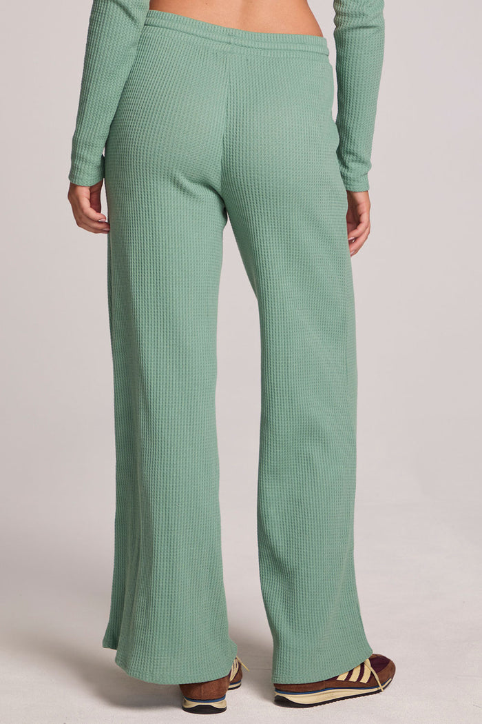 Back view of a woman wearing the Chaser  Jorgia Verdelle Pants on a neutral background