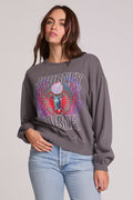 Side view of a woman wearing the Chaser Journey 1983 Tour Sweatshirt on a neutral background with bluejeans and hand on hip