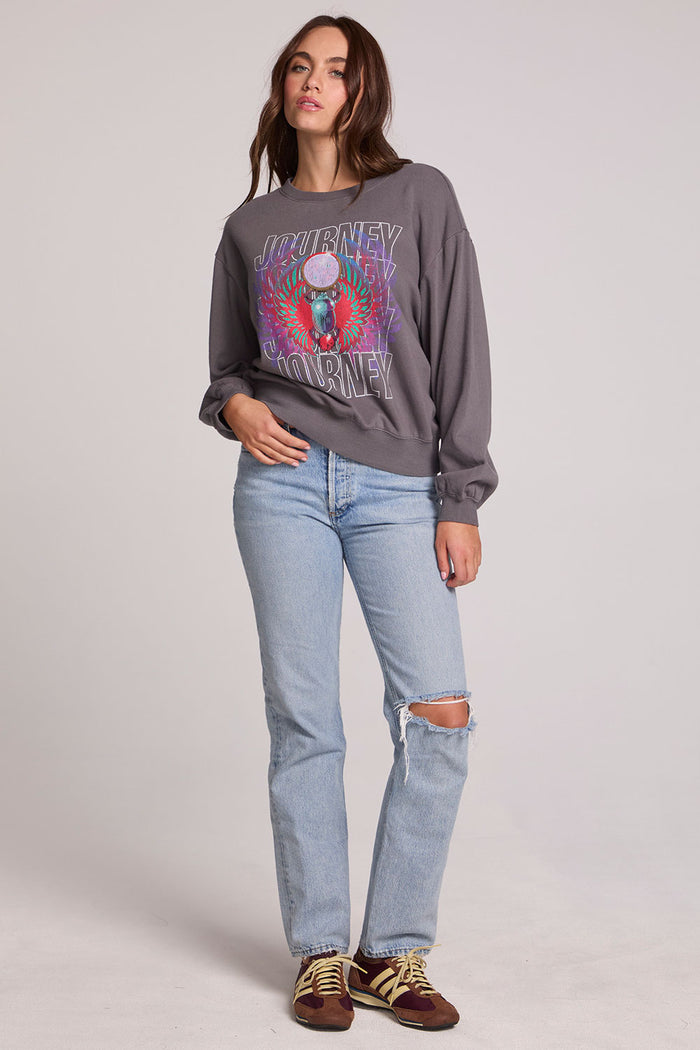 A full body front view of a woman wearing the Chaser Journey 1983 Tour Sweatshirt on a neutral background