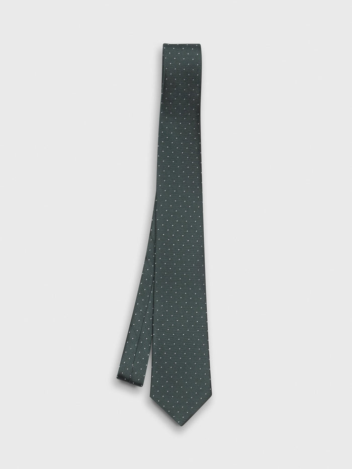 Juniper necktie with white pindots, hanging against a white background.