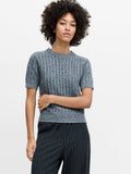 A woman wearing a short sleeved, textured short sleeved grey jumper with a crew neck.