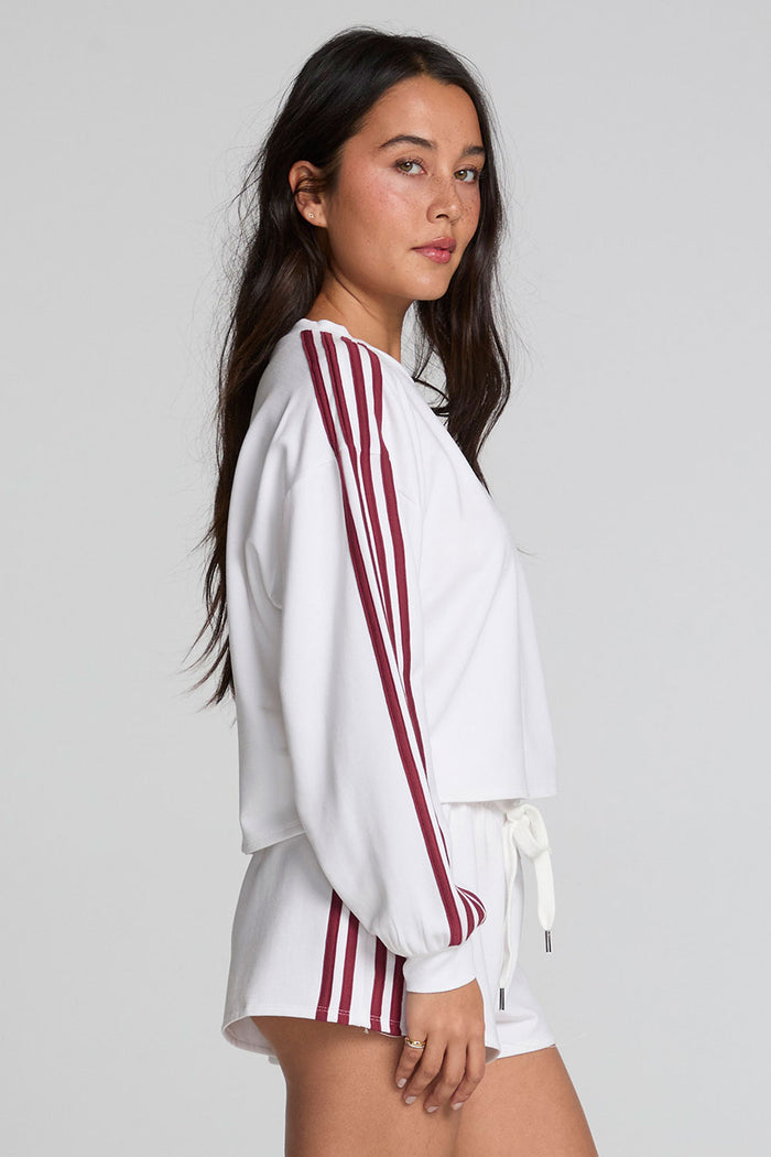 Side view of a woman wearing the Chaser Kloud Cloud White Sweatshirt Set on a neutral background with white shorts