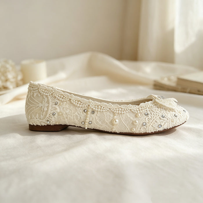 Bride wearing elegant lace wedding flats with crystal bows under a flowing bridal gown during a romantic wedding photoshoot.