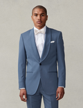 Man in lake blue shawl-lapel tuxedo and ivory bow tie, cropped at waist