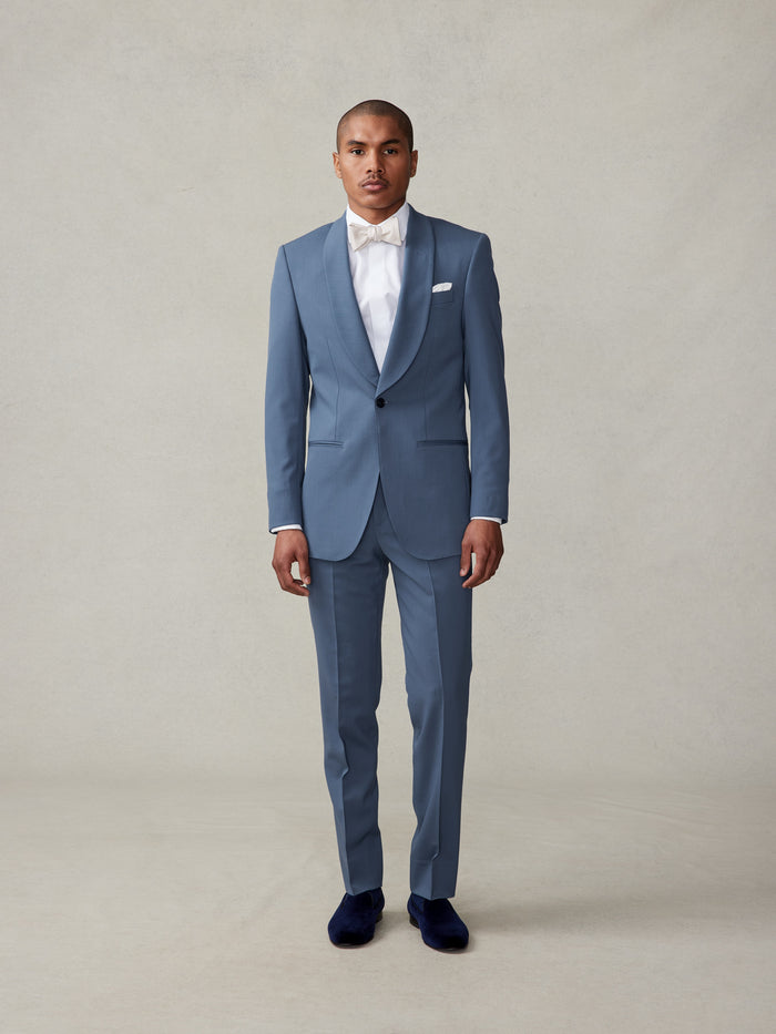 Man in lake blue shawl-lapel tuxedo and ivory bow tie, full-length front view