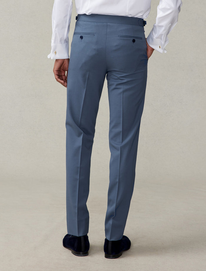 Cropped back view of lake blue tuxedo trousers with navy velvet loafers