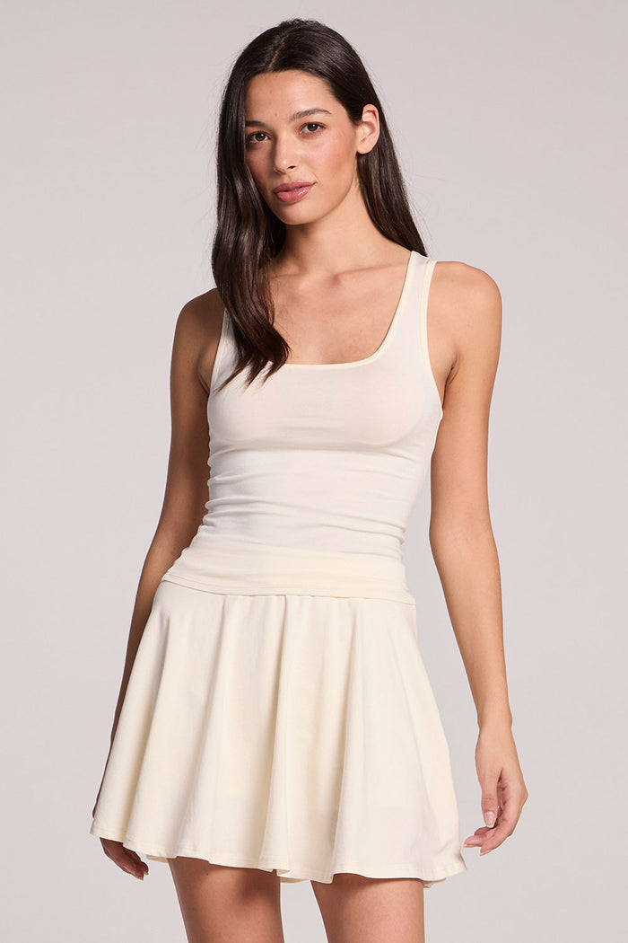 front view of a woman wearing the Chaser Lander Coconut Milk Tank and skirt on a neutral background