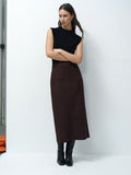 A woman wearing a brown faux suede midi skirt with a back zip fastening and a high waist.