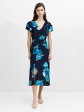 A woman wearing a floral button down flowing midi length blue dress with layered frill sleeves and front split hem.