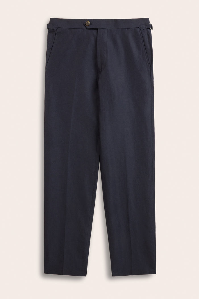 Deepwater navy linen trousers laid flat, side-adjuster tabs and slant side pockets.