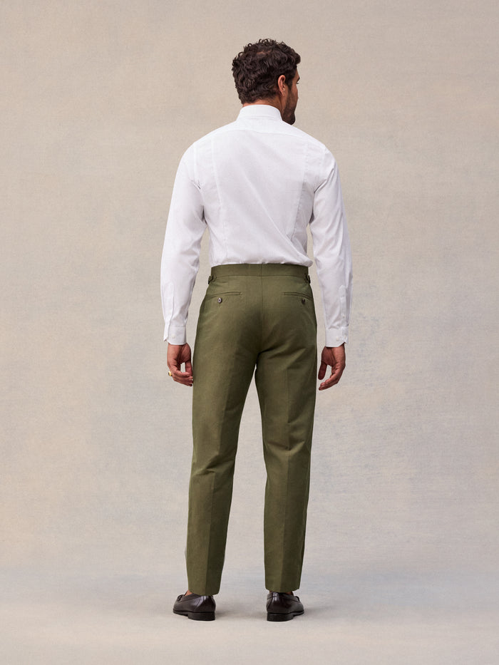 Model in vintage olive suit pant and white dress shirt, full-length back view
