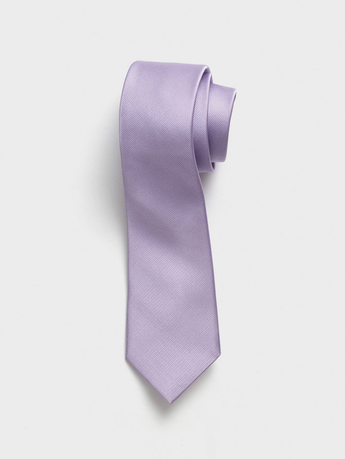 Lavender silk necktie with twill texture, rolled at the top on a grey background.