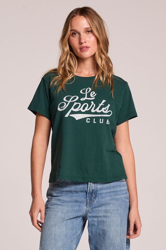 Front view of a woman wearing the Chaser Le Sports Club Tee and jeans on a neutral background