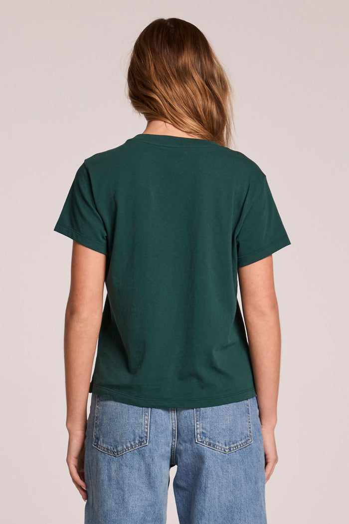 Back view of a woman wearing the Chaser Le Sports Club Tee on a neutral background