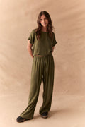 Full front view of Lee Trouser in bronze green with wide-leg silhouette and relaxed drape with matching tee against a beige background