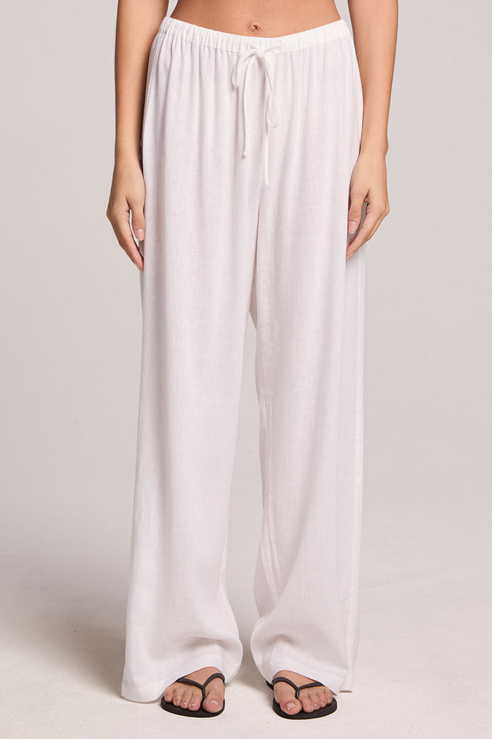 A front view of a woman wearing the Chaser Lee White Trouser  and shoes on a neutral background