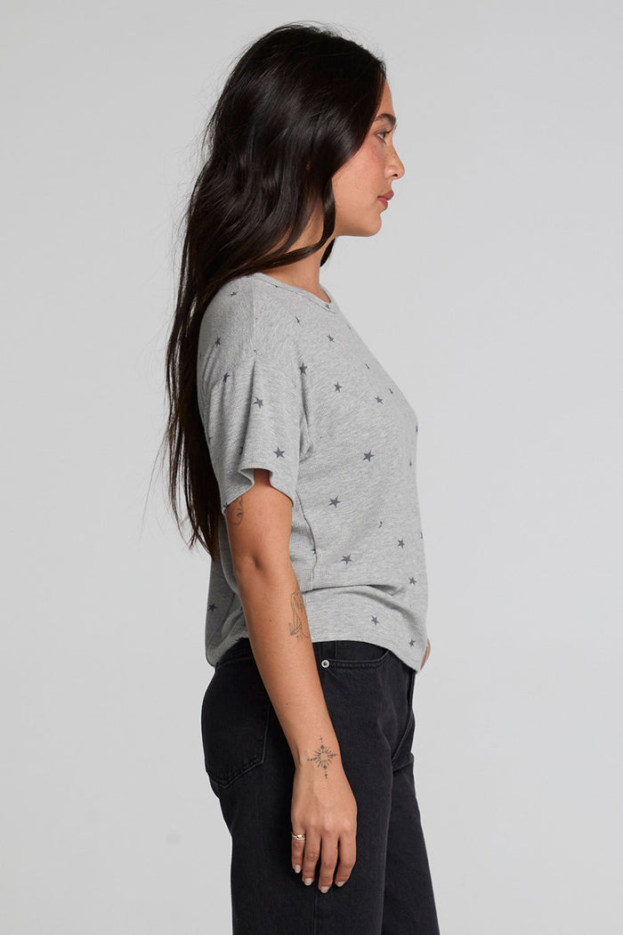 Side view of a woman wearing the Chaser Leonor Light Heather Grey Tee on a neutral background with pants