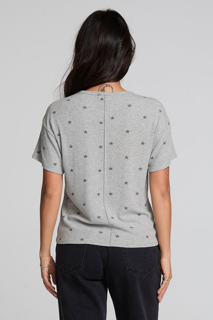 Back view of a woman wearing the Chaser Leonor Light Heather Grey Tee on a neutral background with black pants