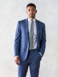 Man in light blue suit jacket, sage tie, and blue pocket square, front view