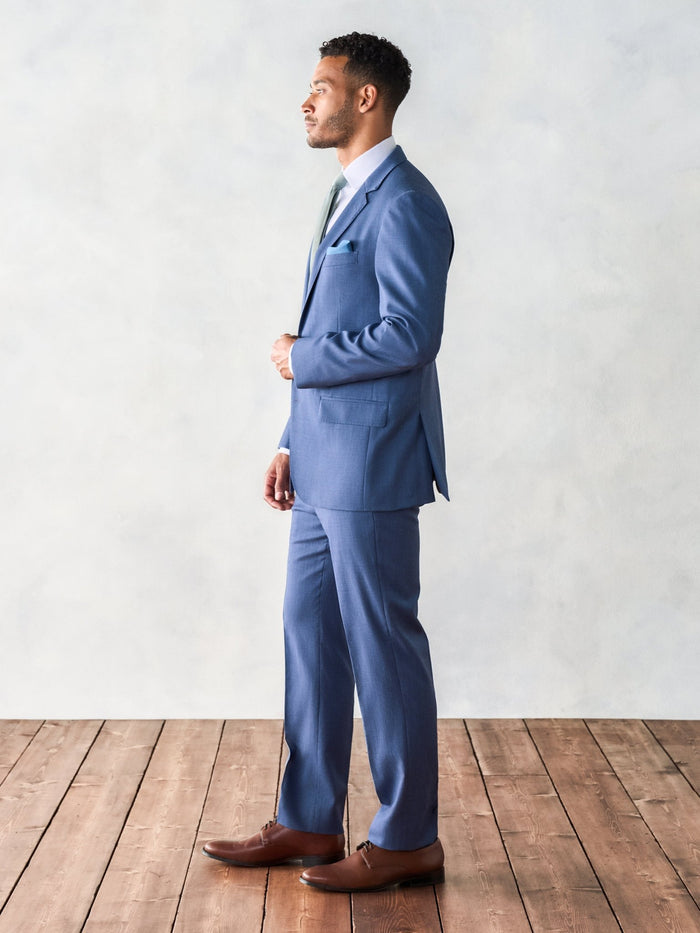Side profile of man in light blue suit jacket with flap pocket detail