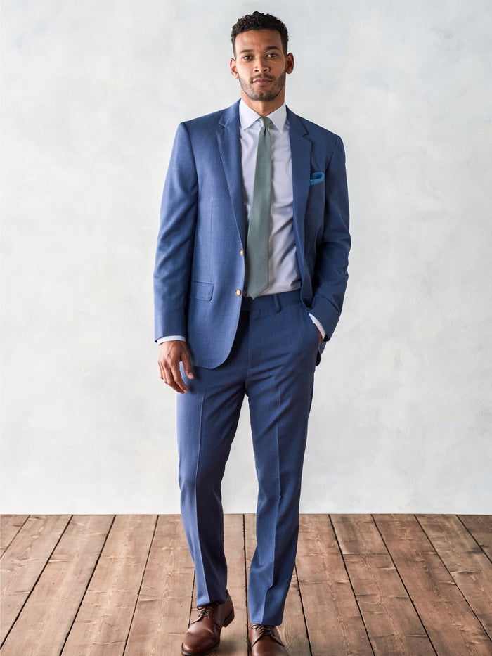 Man in light blue suit, sage tie, and brown shoes, full-length front view