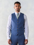 Man in light blue suit vest, sage tie, and white dress shirt, front view