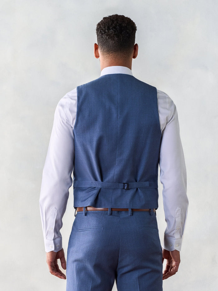 Back view of man in light blue suit vest with adjustable strap buckle