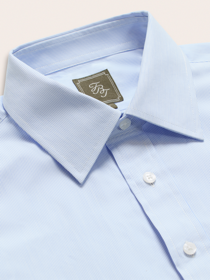 Close-up of light blue and white striped dress shirt collar and brand label