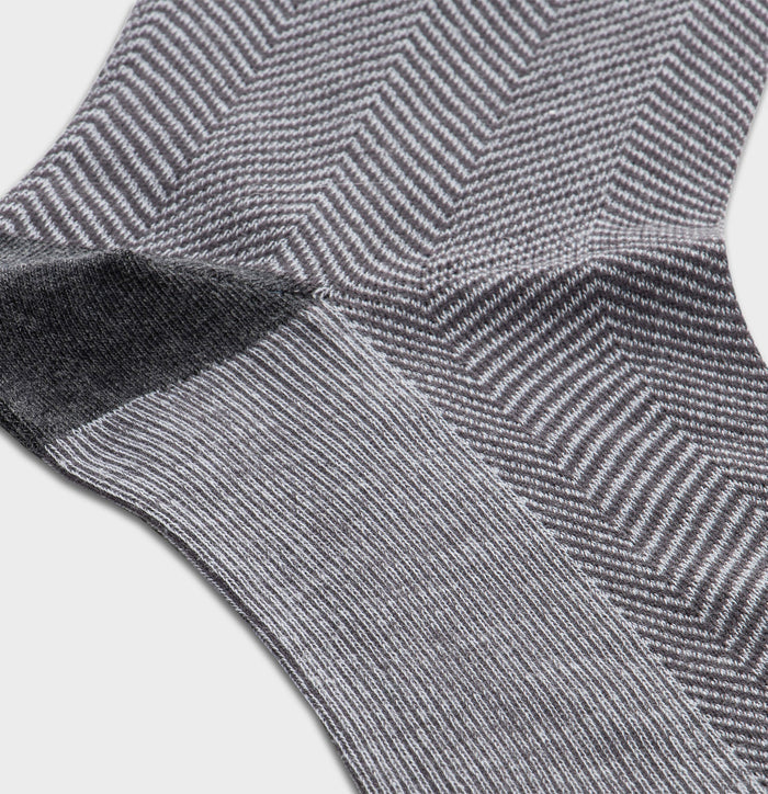 Close-up of light grey herringbone dress sock fabric and heel seam