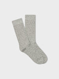 Pair of light grey dress socks with small dark pindot pattern, folded flat on light grey background