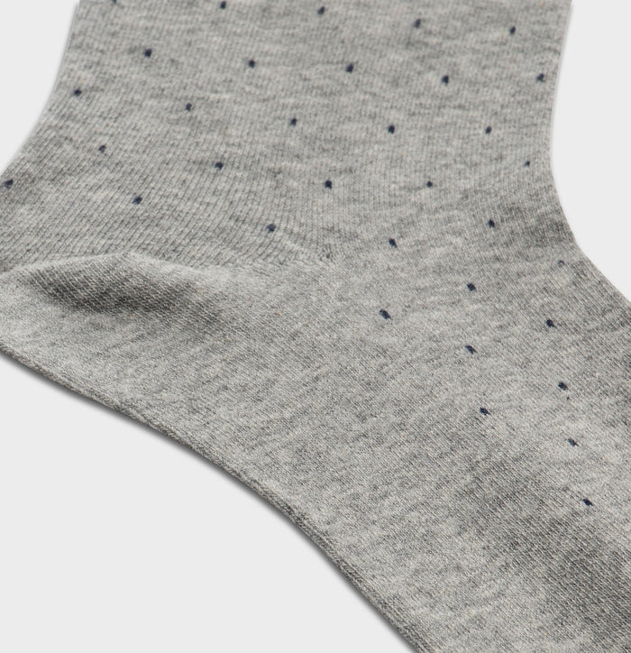 Close-up of light grey pindot dress sock fabric with navy dots