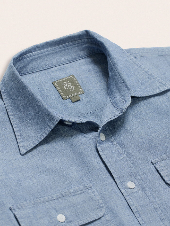 Close-up of light wash chambray work shirt collar and brand label