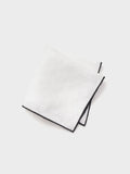 White linen pocket square with black border, folded on white background