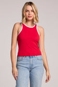 A front view of a woman wearing the Chaser Lisbon Cardinal Red Tank with her hands hanging down  on a neutral background